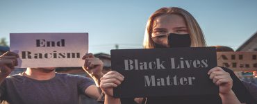 White woman holding BLM sign