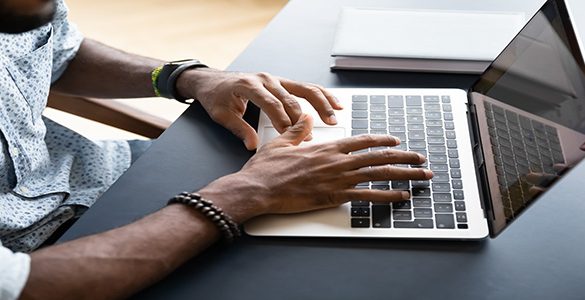 Black hands at computer keyboard