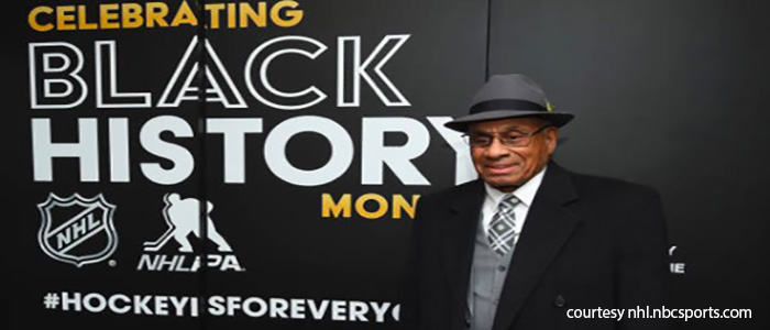 Willie O'Ree infront of Celebrating Black History Month Bbanner