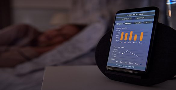 Woman Sleeping In Bed With Sleep Data App Running On Mobile Phone On Bedside